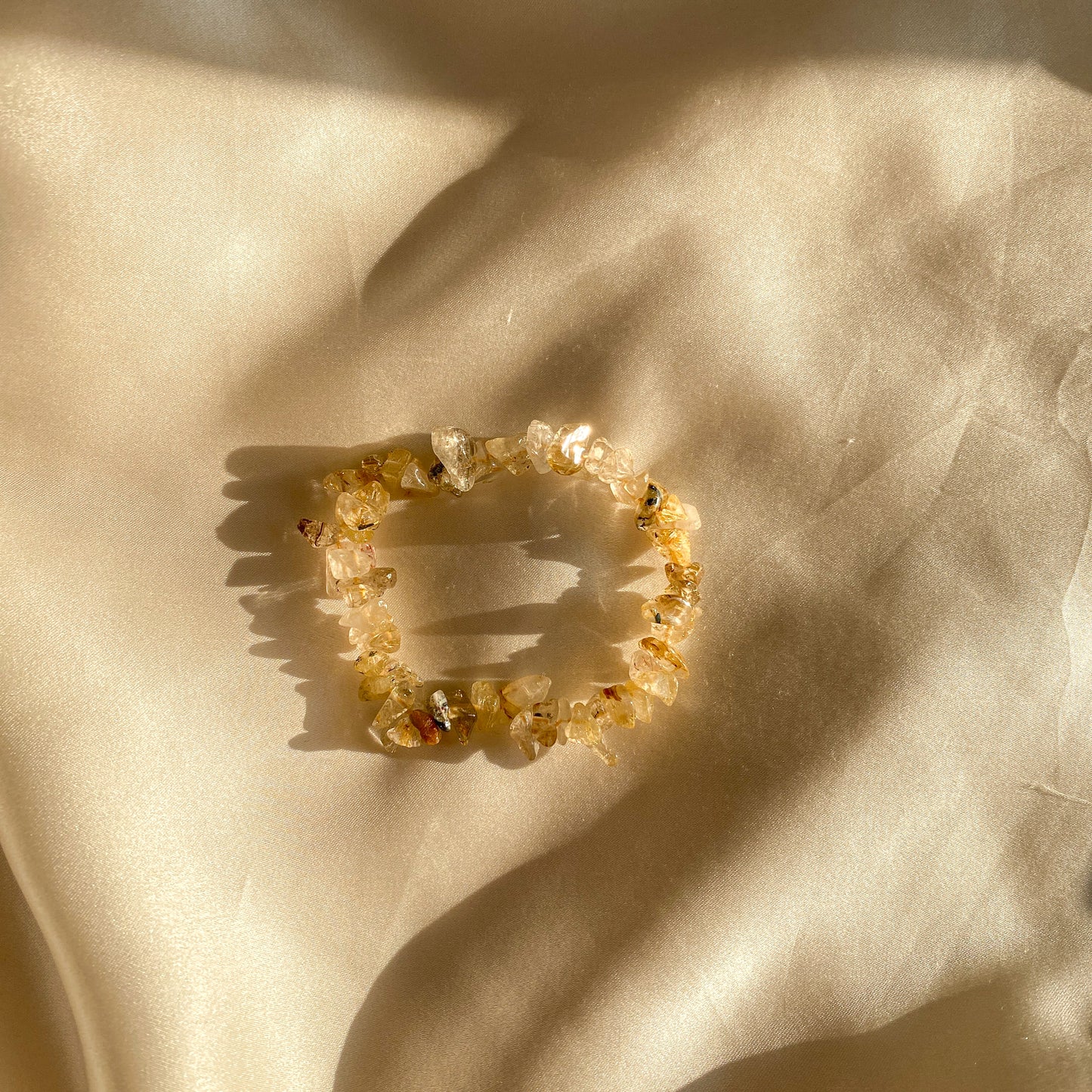 Ein Rutilquarzarmband in harmonischen Erdtönen, kunstvoll gefertigt und mit schimmernden Rutilnadeln durchzogen. Das Armband symbolisiert Schutz, spirituelles Wachstum und körperliches Gleichgewicht. Ein Unikat aus Naturprodukten, das deine Wahrheit und innere Stärke widerspiegelt