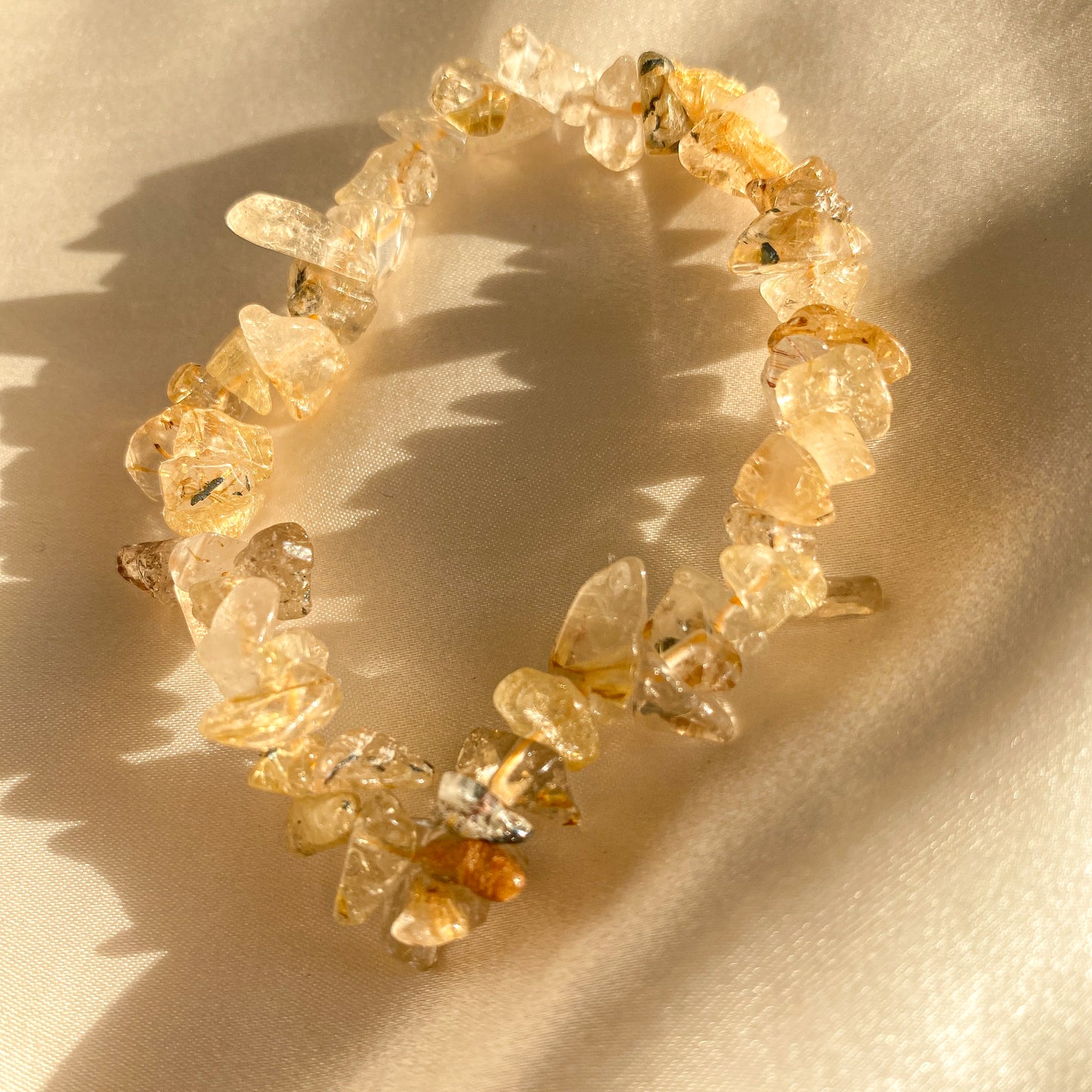 Ein Rutilquarzarmband in harmonischen Erdtönen, kunstvoll gefertigt und mit schimmernden Rutilnadeln durchzogen. Das Armband symbolisiert Schutz, spirituelles Wachstum und körperliches Gleichgewicht. Ein Unikat aus Naturprodukten, das deine Wahrheit und innere Stärke widerspiegelt