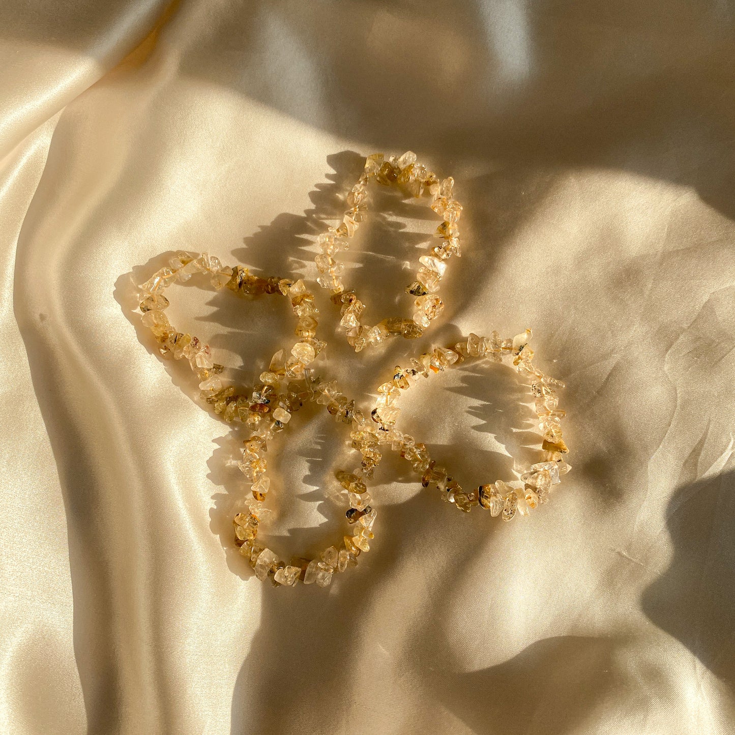Ein Rutilquarzarmband in harmonischen Erdtönen, kunstvoll gefertigt und mit schimmernden Rutilnadeln durchzogen. Das Armband symbolisiert Schutz, spirituelles Wachstum und körperliches Gleichgewicht. Ein Unikat aus Naturprodukten, das deine Wahrheit und innere Stärke widerspiegelt